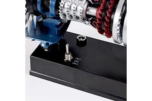 Close-up of the base of a Teching DM122 turbofan engine model, showing the metal toggle switch labeled ON-1, OFF, and ON-2 on a black plastic stand.