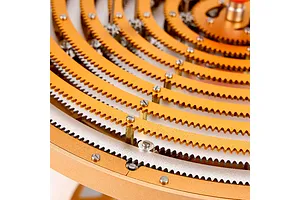 Close-up of the concentric gold-colored metal gear rings of a Teching DM405 solar system model kit.