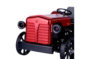 Close-up of the front of a red metal Teching DM616 RC tractor model kit showing the grille, headlights, and front wheels.