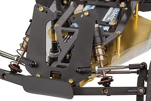 Close-up of the front suspension and shock tower of a Team Associated RC10 buggy with a gold chassis.