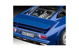 A close-up view of the rear section of a blue Bugatti EB 110 model car, showing the engine bay, rear spoiler, taillights, and German license plate.