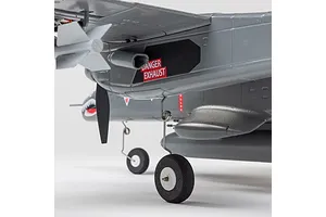 Close-up of the E-Flite Micro OV-10 Bronco RC plane showing the landing gear, propeller, and exhaust detail with a danger warning label.