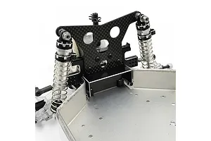 A close-up of an RC car rear bulkhead assembly featuring a black aluminium bulkhead, carbon fiber shock tower, and silver coil-over shocks on a metal chassis.