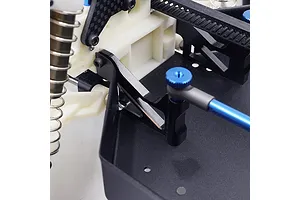 Close-up of a black aluminium servo mount and chassis brace installed on an RC car chassis.