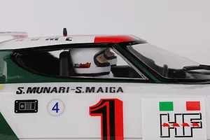 Side view of a Killerbody Lancia Stratos RC car body showing the cockpit with a driver wearing a white helmet and racing decals on the door.