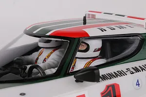 Close-up of the interior cockpit of a Killerbody Lancia Stratos RC car, showing two driver figures in white racing suits and helmets.