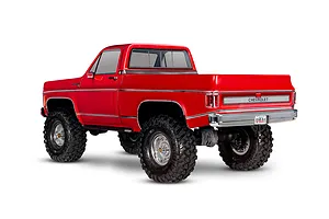 Rear three-quarter view of a red Traxxas TRX-4 1979 Chevrolet Cheyenne K10 RC rock crawler truck on a white background.
