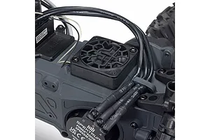 Close-up view of an ARRMA RC vehicle chassis showing the Spektrum Firma brushless motor, cooling fan, and wiring.