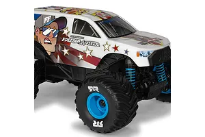 ARRMA Freedom Flyer Grom 1/16 scale RC monster truck with Cleetus McFarland graphics, blue springs, and blue wheels on a white background.
