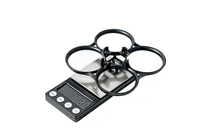 A black BetaFPV drone frame duct sitting on a digital scale against a white background.