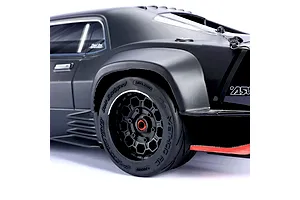 Close-up of a Method RC belted tyre and black hive rim mounted on the rear of a matte black RC car.