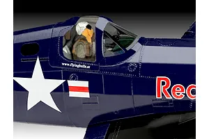 Close-up of a painted plastic model F4U-4 Corsair cockpit showing a pilot figure, dark blue fuselage, white star insignia, and Red Bull branding.