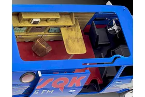 Top-down view of the interior of a Revell 1/25 scale model van with a blue exterior, red floor, and detailed shelving unit.