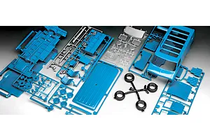 An overhead view of unpainted blue plastic model van parts on sprues, including a van body, interior panels, wheels, and clear plastic windows.