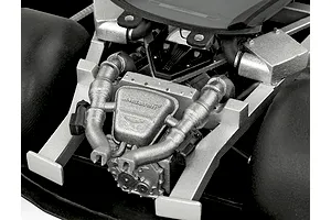Close-up of the detailed engine bay of a 1/24 scale McLaren 750S model car kit, showing the silver engine block and intake manifold.