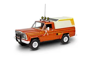 A 1/24 scale model of an orange Jeep J-10 pickup truck with a white camper shell, roof lights, and off-road tires, shown against a white background.
