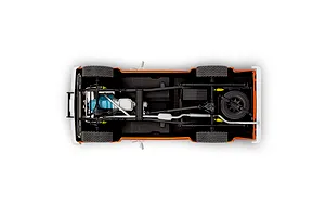 Underside view of a 1/24 scale model Jeep J-10 pickup truck showing the chassis, drivetrain, exhaust system, and spare tire.