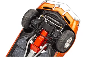 Underside view of a detailed orange 1968 Corvette model car showing the engine, suspension, and chassis components.