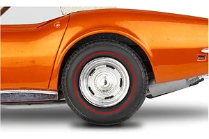 Close-up of the rear wheel and fender of an orange 1/25 scale model Corvette with a red-line tire and chrome rally wheel.