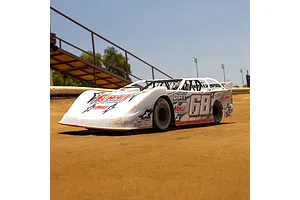 A white Losi 22S Dirt Late Model RC car with number 68 livery sitting on a dirt track.