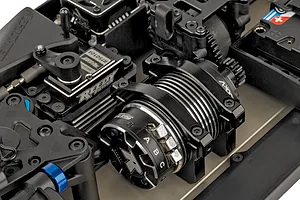 Close-up of the internal chassis components of a Team Associated RC8T4.2e RC truggy, showing the electric motor, Reedy servo, and drivetrain parts.