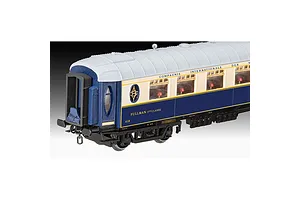 A close-up of a 1/87 scale model Orient Express Pullman carriage with blue and cream livery against a black and white gradient background.