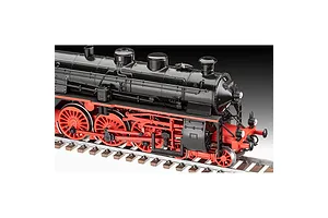 A detailed 1/87 scale plastic model of a black and red steam locomotive sitting on model train tracks.