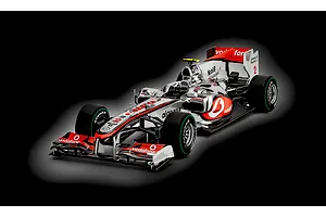 A studio shot of a 1/24 scale model of the Vodafone McLaren Mercedes MP4-25 Formula 1 car, featuring chrome, red, and white livery on a black background.