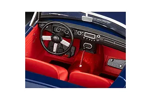 Close-up view of the detailed red interior and black dashboard of a 1/32 scale MGB Roadster model car kit.