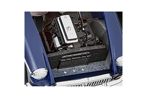 Close-up of the engine bay of a blue Revell 1/32 MGB Roadster model car kit, showing the detailed engine block and radiator.