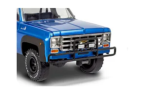 Close-up of the front end of a blue 1978 Chevy pickup model kit with a black brush guard and off-road tires.