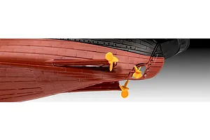 Close-up view of the stern section of a plastic model ship kit showing the red hull, black upper section, and three yellow propellers.