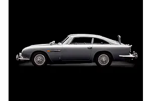 Side view of a silver Aston Martin DB5 model car on a black background.