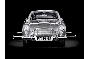 Front view of a silver Aston Martin DB5 model car with extended wheel spinners on a black background.