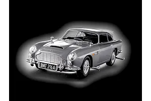 A 1/24 scale model of the James Bond Aston Martin DB5, finished in silver with wire wheels and BMT 216A license plate, set against a black background.
