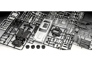 Plastic model kit parts for a 1/24 scale Aston Martin DB5, including a silver car body, black chassis, and various grey and chrome sprues.