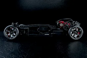 Side profile view of an MST RMX 4.0 RC drift car chassis showing the motor, wheels, and internal electronics on a black background.