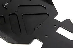 Close-up of a black anodized aluminium RC main chassis plate featuring various cutouts and mounting holes.