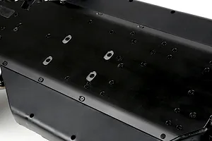 A close-up view of the black underside of a Rovan LT RC car main chassis, showing numerous screw holes and mounting points.