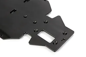 A close-up view of a black anodized aluminium RC main chassis plate featuring various mounting holes and a central rectangular cutout.