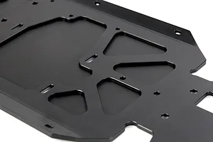 A close-up view of a black anodized aluminium RC main chassis plate with various mounting holes and cutouts.
