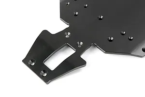 A close-up view of a black anodized aluminium V5 main chassis plate for an RC car, showing the front section with mounting holes and a central cutout.