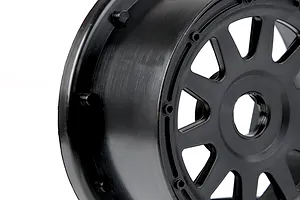 A close-up view of a black plastic RC short course rear wheel rim against a white background.