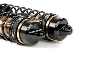 Close-up of two Rovan bronze aluminium adjustable RC shock absorbers with black springs and caps against a white background.