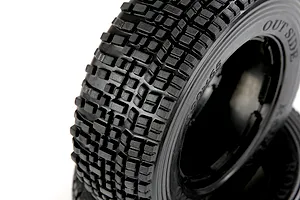 Close-up of a black Rovan 1/5 scale RC short course truck tyre with a blocky tread pattern, showing the sidewall markings against a white background.