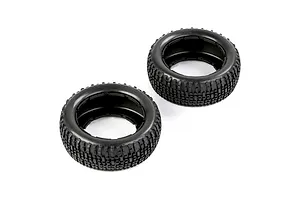 Two black rubber RC short course truck tyres with a blocky tread pattern, viewed from an angle on a white background.
