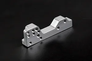 A silver Rovan aluminium engine mount for RC cars, featuring multiple pre-drilled screw holes, isolated against a dark background.
