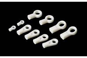 A set of various sizes of white plastic RC rod ends arranged on a black background.