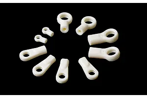 A collection of various white plastic RC ball ends arranged in a circle against a black background.