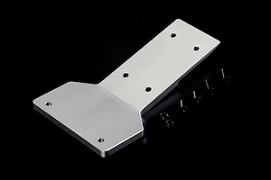 A silver aluminium front skid plate for an RC car, accompanied by four black screws and two black nuts, set against a plain black background.